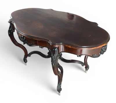 une table basse ovale en acajou, avec des pieds sculptés et un plateau incurvé