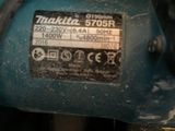 a close up of a blue machine with a black handle
