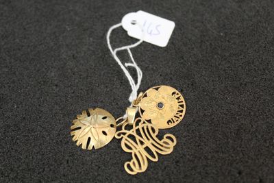 a close up of a gold necklace with a tag on it