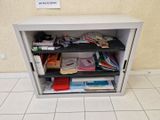 une petite armoire sur laquelle sont posés de nombreux livres et papiers