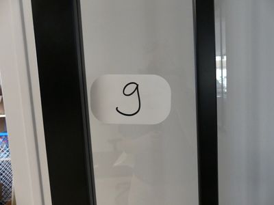 une photo en noir et blanc d'une porte sur laquelle est accrochée une pancarte