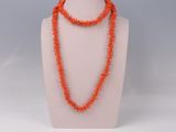 an orange beaded necklace on a mannequin display