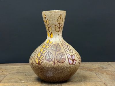 un petit vase posé sur une table en bois