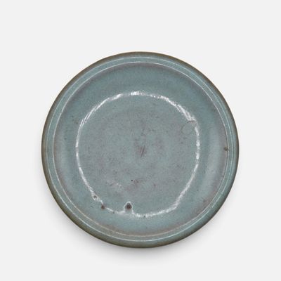 a blue plate on a white table with a white background
