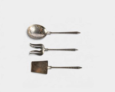 trois cuillères et une fourchette sur une surface blanche