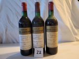trois bouteilles de vin posées sur une table, avec une étiquette de prix