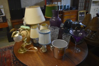 a table with a lamp, cups, and other items on it