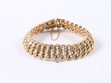 a close up of a gold bracelet on a white background