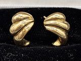pair of gold tone earrings in a black velvet box