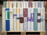 de nombreux rouleaux de tissu sur une palette dans un entrepôt