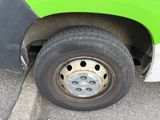 a close up of a flat tire on a green bus