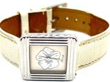 une montre blanche avec une fleur sur le cadran