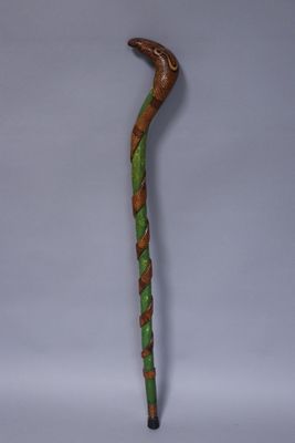 a wooden walking stick with a green and brown design on it