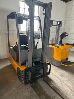 un chariot élévateur jaune garé dans un entrepôt
