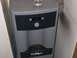 a water dispenser in the corner of a bathroom