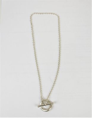 un collier en argent orné d'un oiseau sur fond blanc