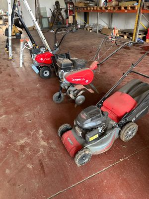 two lawn mowers that are sitting in a garage