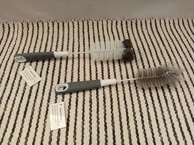 two brushes that are laying on a striped surface