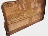 an image of a wooden bed with a rattan headboard