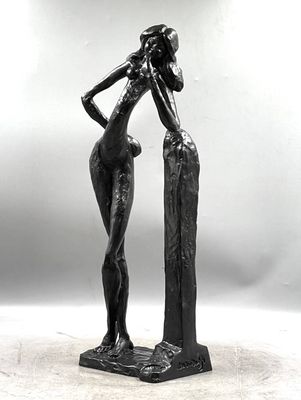 statue d'une femme debout sur un rocher, les mains sur la tête