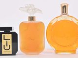 three bottles of perfume sitting next to each other on a white surface