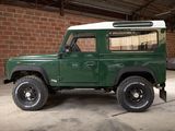 a picture of a green land rover parked in a garage
