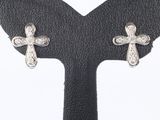 pair of diamond cross earrings on a black leather surface
