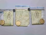 trois sachets de pièces d'or et une pièce de dix cents posés sur une surface blanche