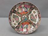 une image représentant une assiette ornée d'un motif représentant des personnes et des fleurs