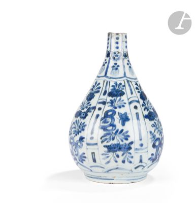 un vase bleu et blanc posé sur une surface blanche