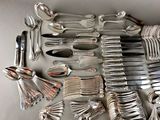 a lot of silver spoons and forks on the table