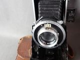 an old camera sitting on top of a piece of luggage
