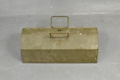 gold metal tool box with handle and latch on white surface