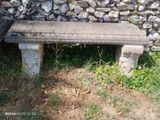 un banc en pierre posé devant un mur en pierre