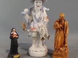 three figurines of a man and a woman standing next to each other
