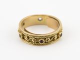 un gros plan d'une bague en or sertie de pierres noires