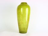 un vase vert posé sur une surface blanche