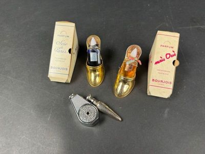 three miniature shoes and a bottle of perfume on a table