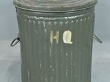 a metal trash can with a lid on a table