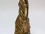 an antique bronze statue of a woman in a dress on a marble base