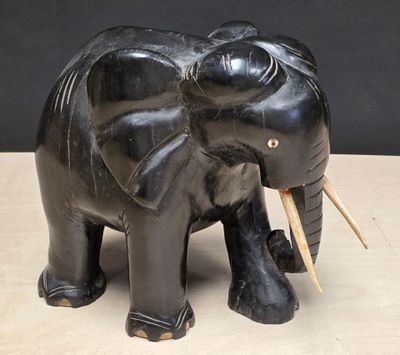 a black elephant statue on a table with a black background