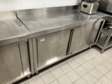 un plan de travail en acier inoxydable dans une cuisine, sur lequel est posé un grille-pain