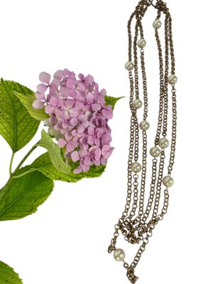 un collier orné de perles et d'une fleur sur fond blanc