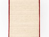 an old book with a red cover and red trim on a white surface