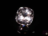 gros plan d'un diamant blanc sur une surface noire