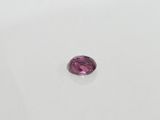 a pink tourmaline stone on a white surface