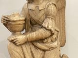 an image of a statue of an angel holding a bowl of fruit