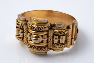 an image of a close up of a gold bracelet on a white surface