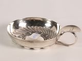a silver bowl with a spoon in it on a white surface