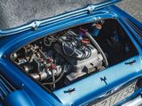 a blue car with an engine in the trunk of it